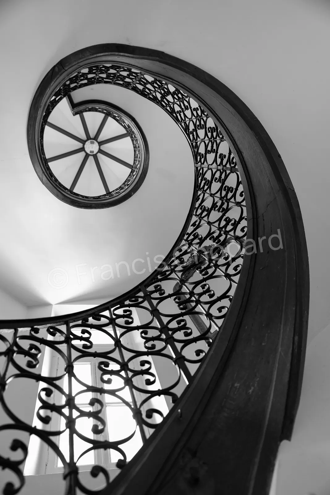 Escalier en spirale et rampe en fer forgé vus du bas