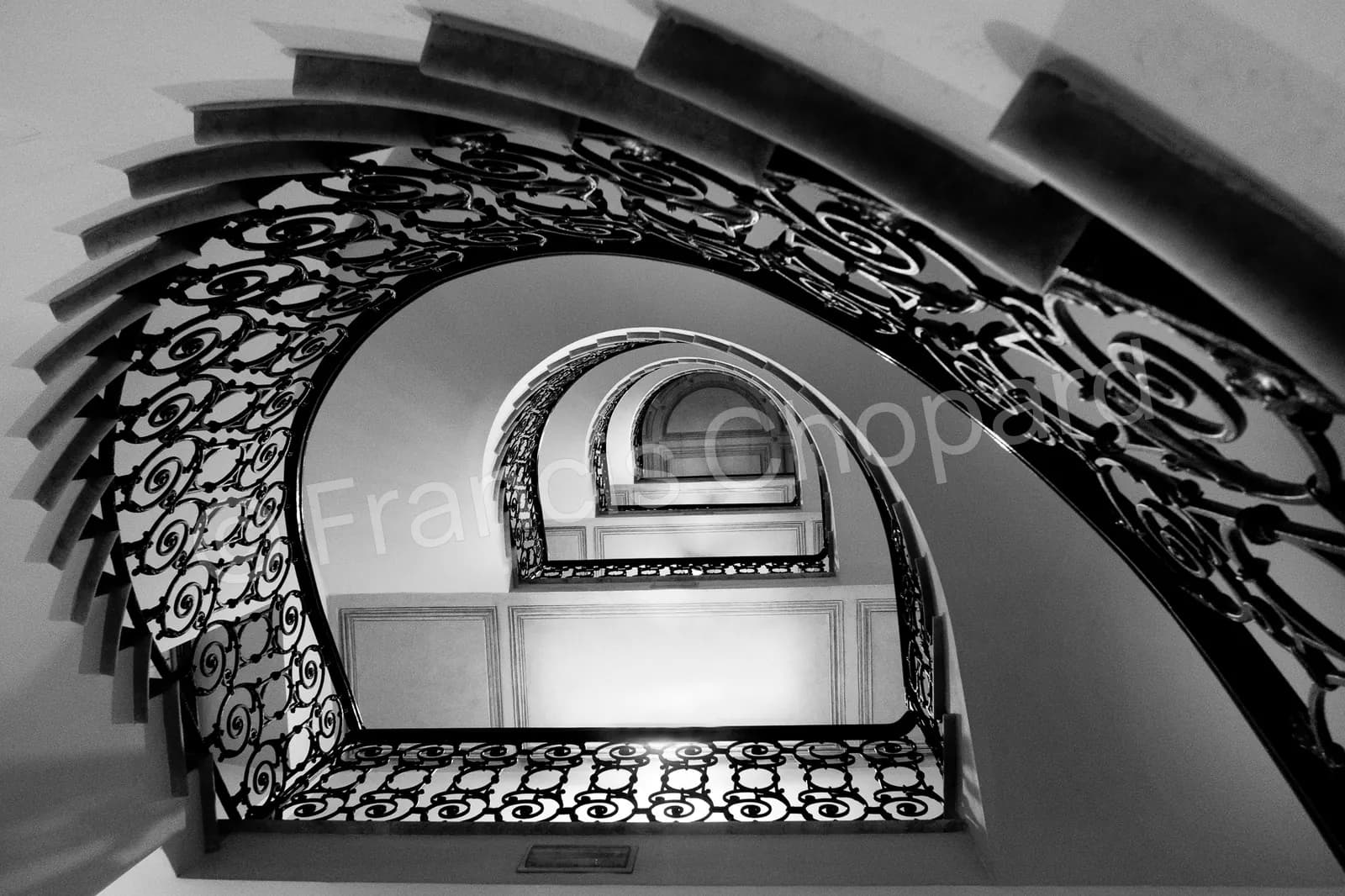 Courbes de ferronnerie sous une volée d’escalier