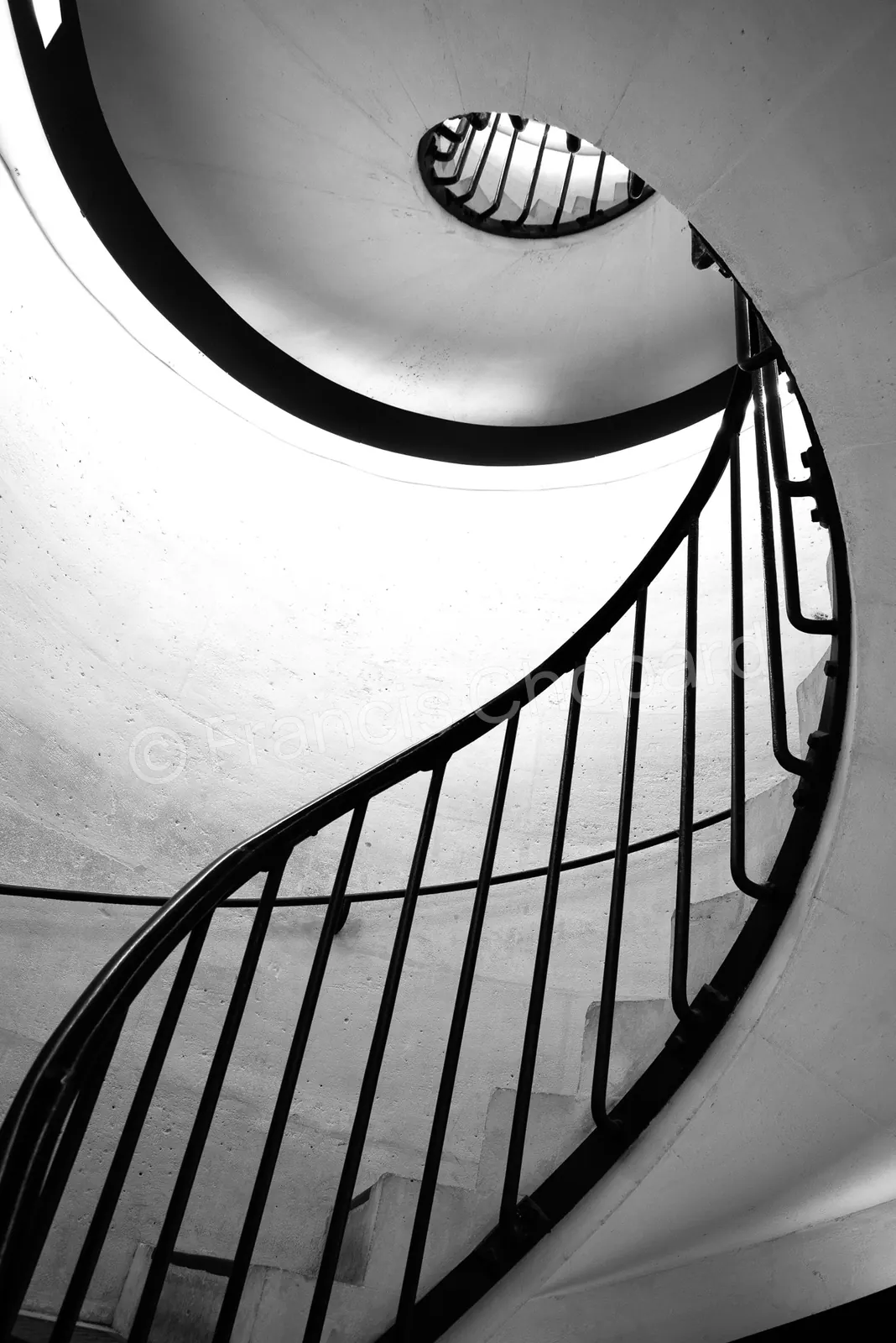 Courbe lumineuse et barreaux noirs d’un escalier