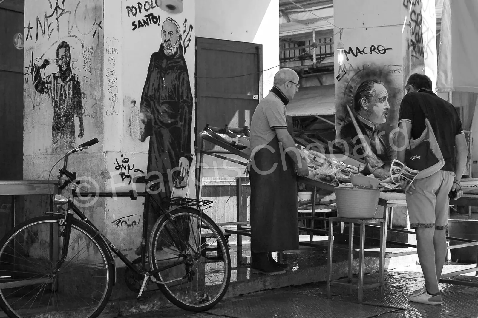 Rencontre sur un marché entre étals et portraits peints